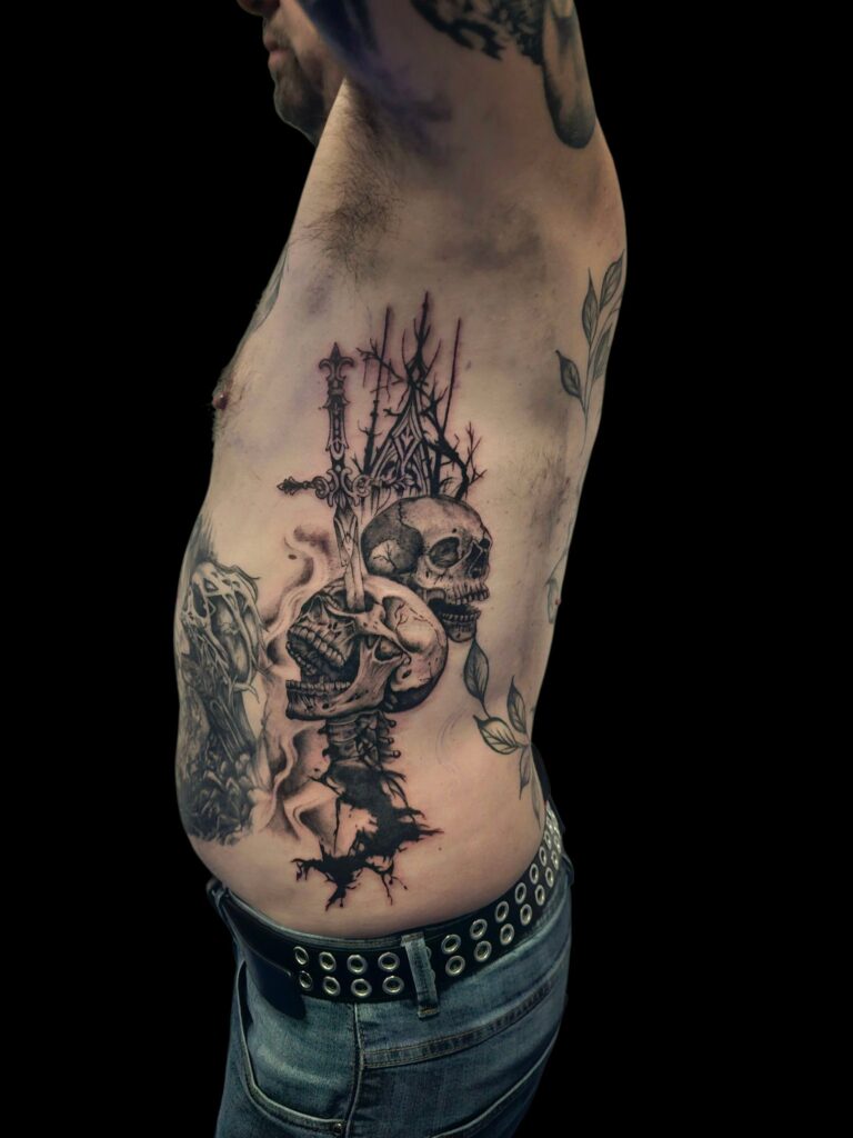 az-tattoo - tatouage côtes deus crânes dont un transpercé par une épée